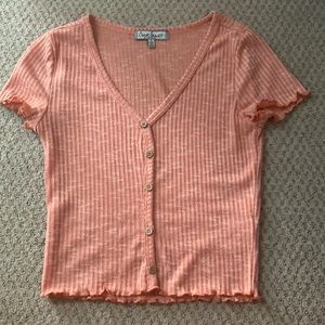 Peach colored shirt with buttons down the middle